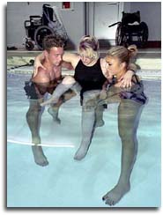Photo of two students helping a third exercise in pool