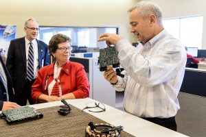 University of Wisconsin-Madison Chancellor Rebecca Blank (center) and Ian Robertson, dean of the College of Engineering (left) listen as George Broughton, director of Advanced Engineering and Innovation BRP / Evinrude (right), talks about engine innovations during a tour of the company's facilities in Sturdevant, WI on Oct. 18, 2016. (Photo by Bryce Richter / UW-Madison)