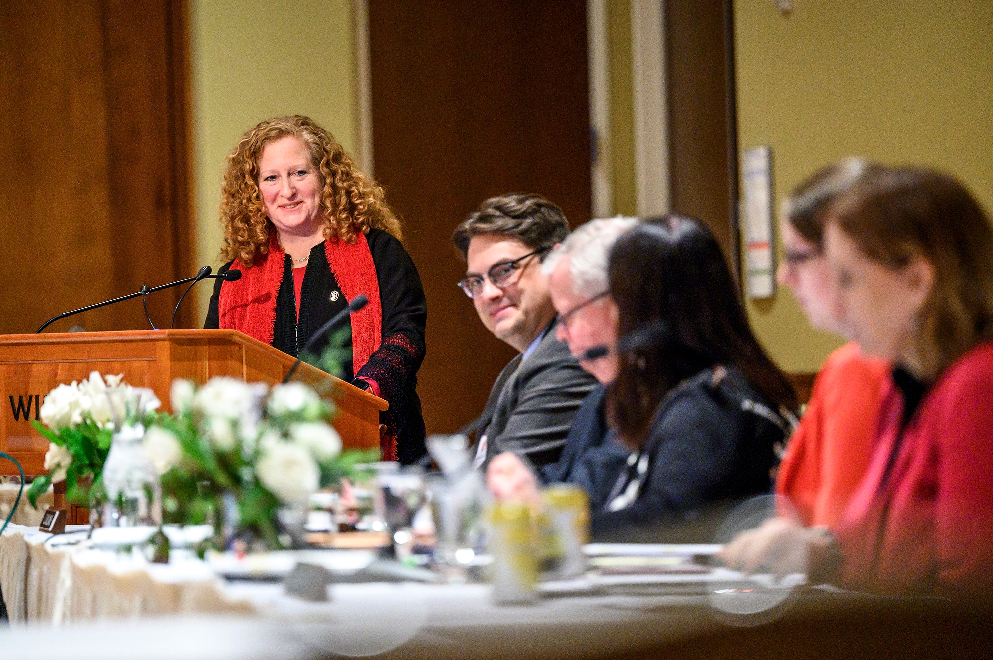 UW–Madison Chancellor Jennifer Mnookin smiling from behind a lectern while looking toward members of the UW System Board of Regents.