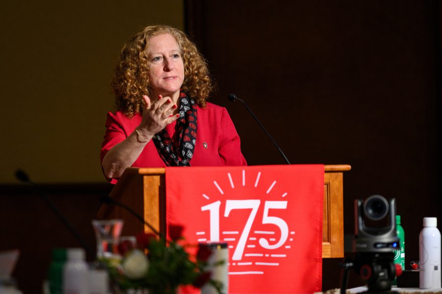 Chancellor Mnookin delivering speech standing at podium decorated with red UW–Madison 175th anniversary banner