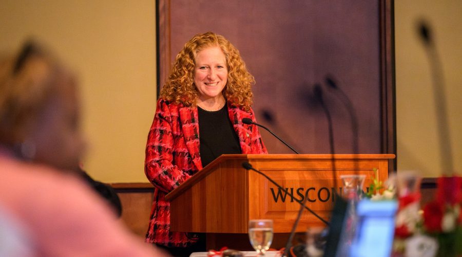 A woman stands at a podium and speaks.