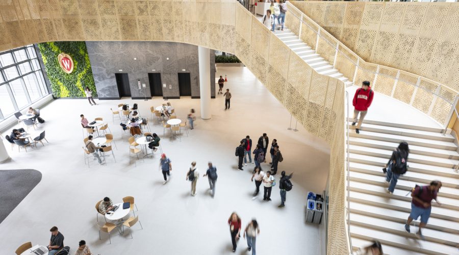Students fill the lobby of Morgridge Hall as they walk to and from classes or sit at tables scattered throughout the space.