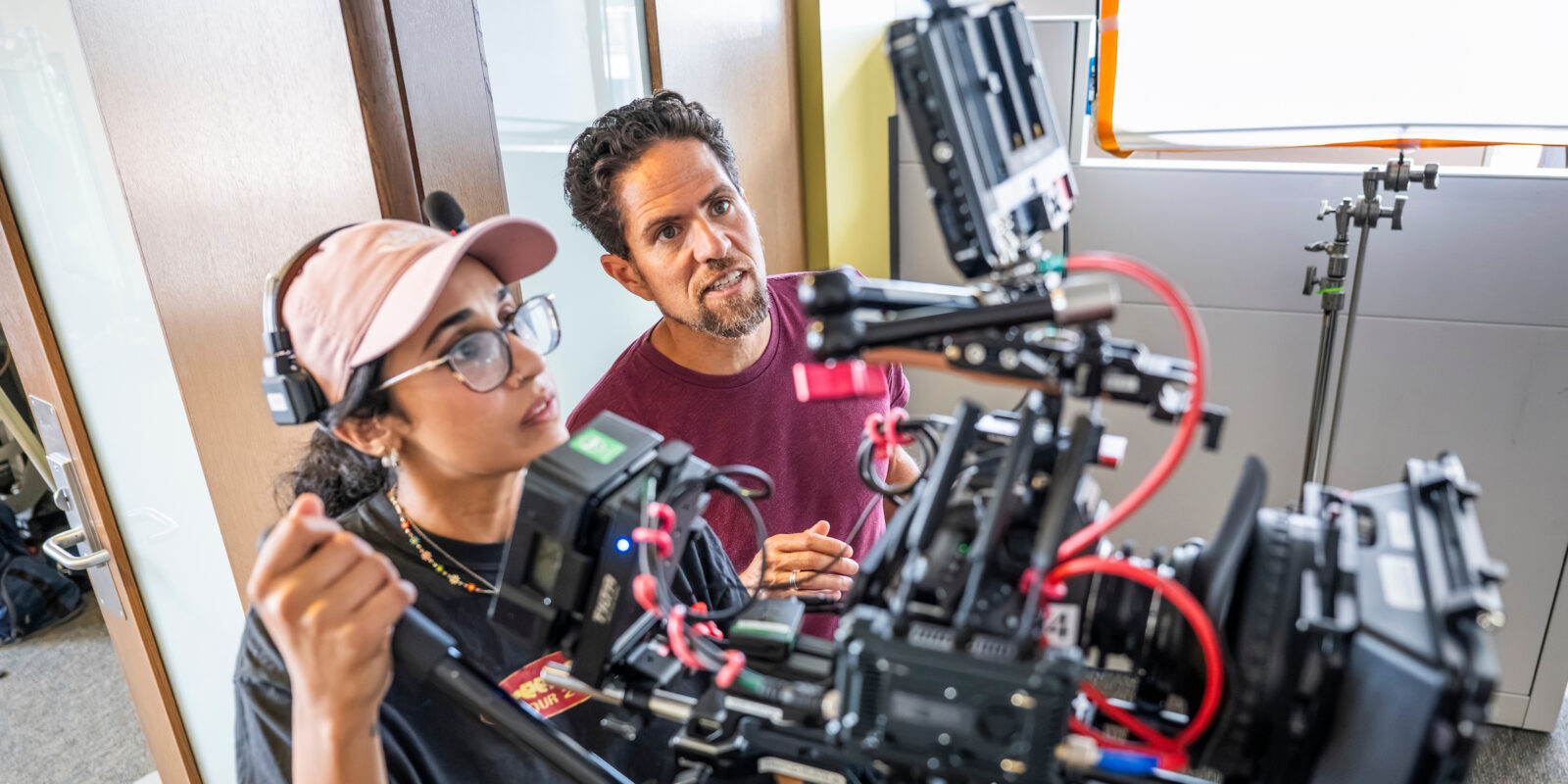 Two people starring intently at a screen of a camera while filming